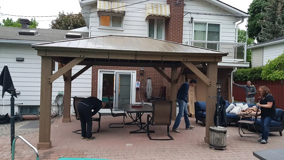 Structure d’un gazebo en bois en cours de montage sur une terrasse