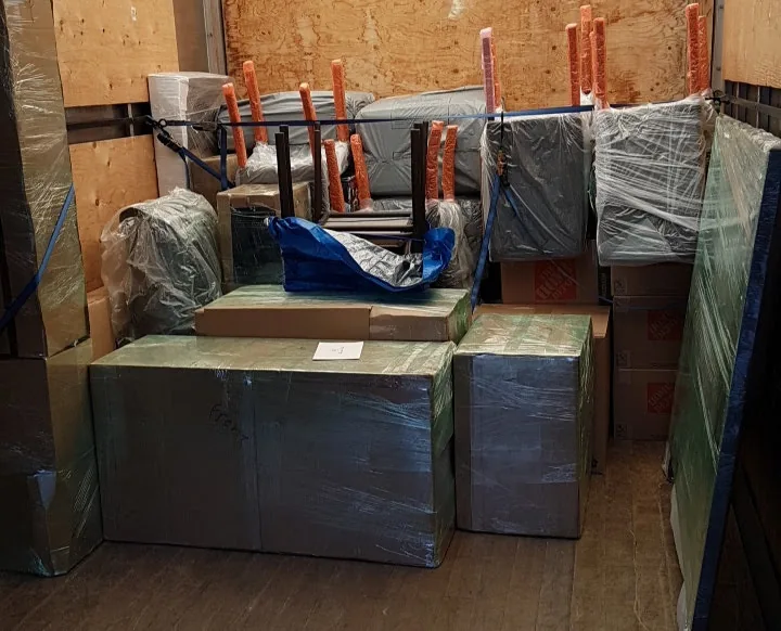 Meubles enveloppés et maintenus par des sangles dans un camion de déménagement